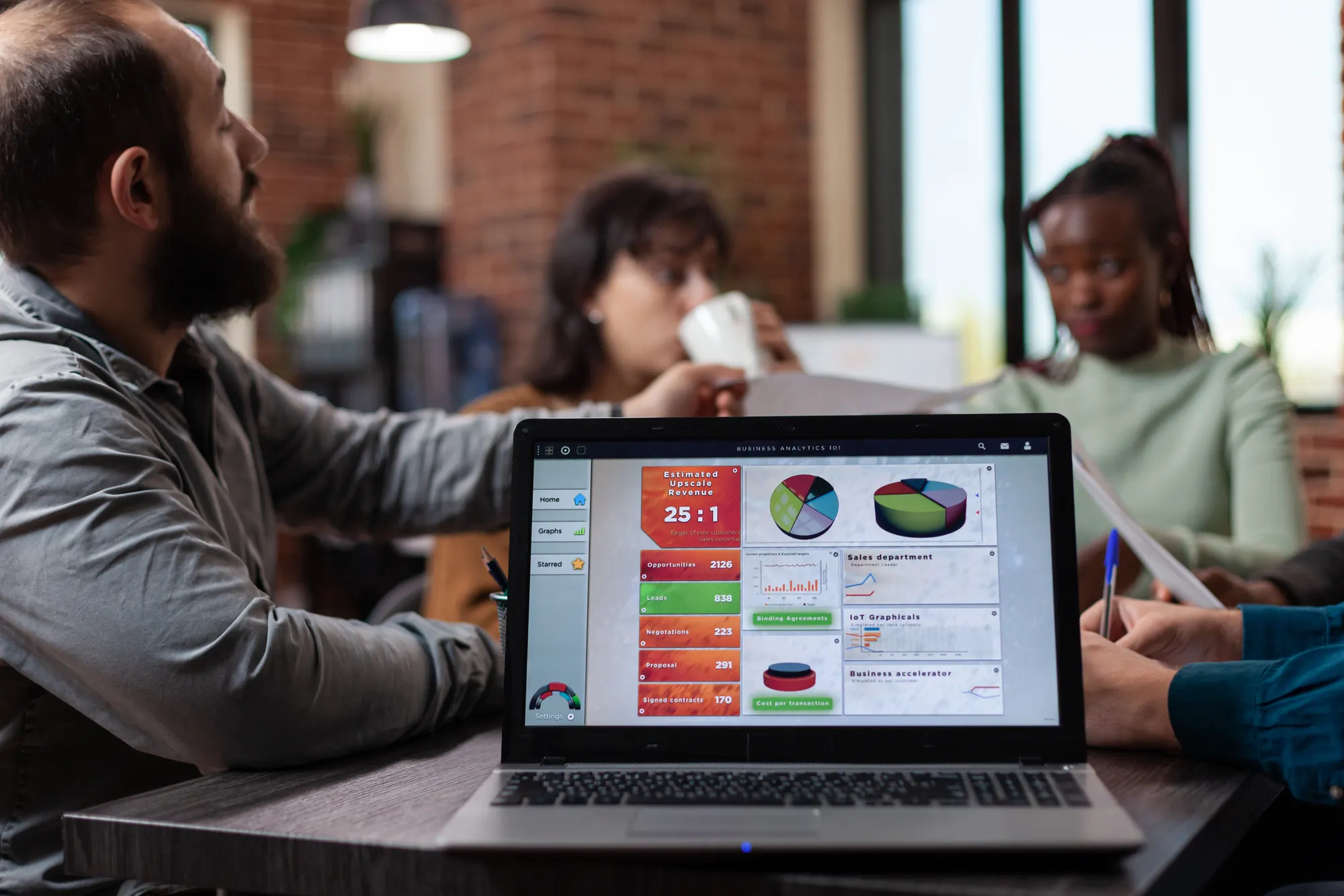 A client team reviewing a dashboard of leads and revenue on a laptop